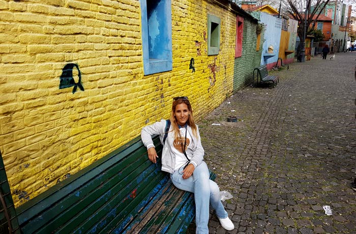 Estefanía, sentada en un banco de Caminito visitar La Boca